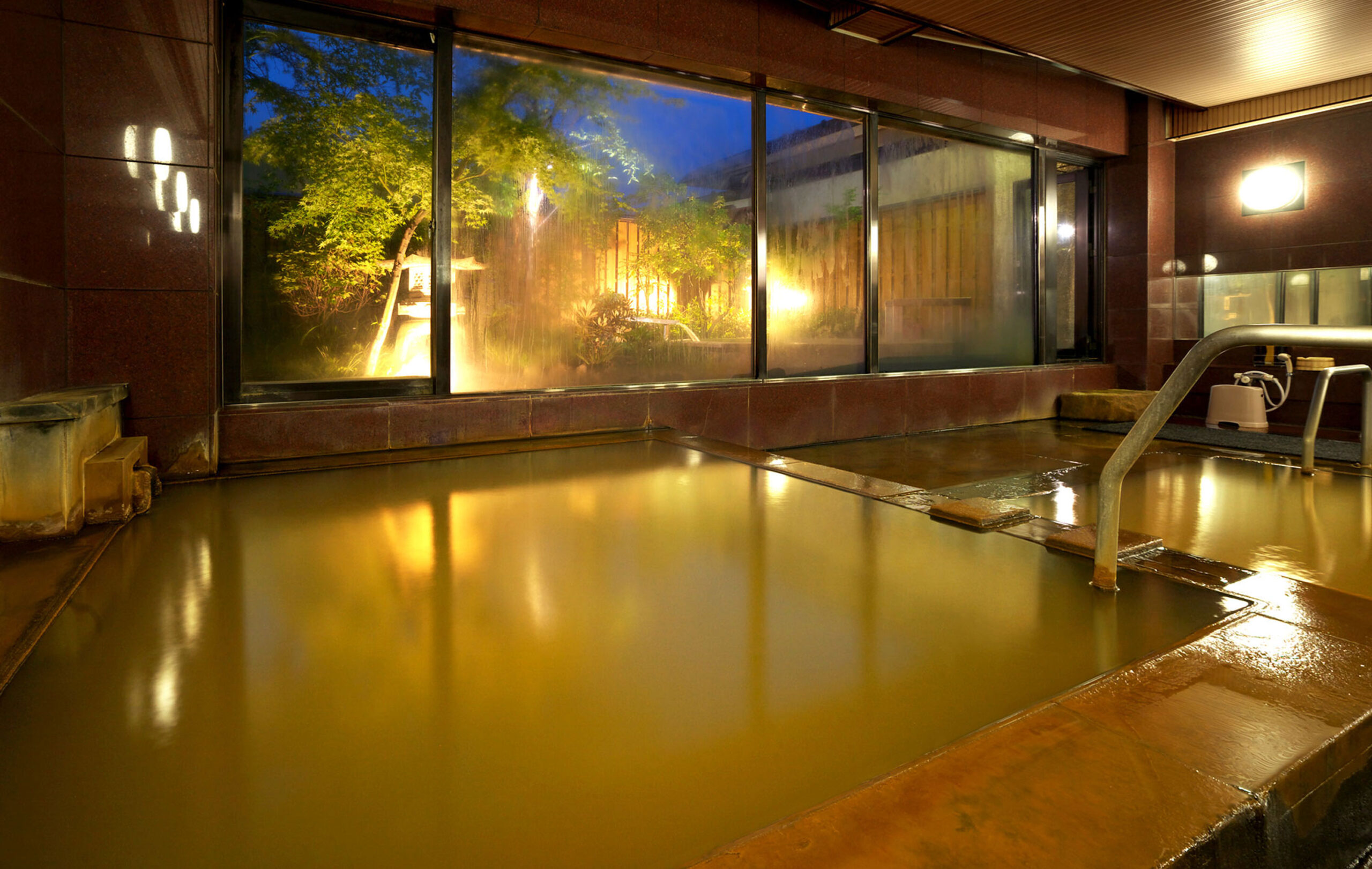 塚越屋七兵衛 — 伊香保石段街沿い · 黄金の湯の褐色の湯面と窓越しの庭