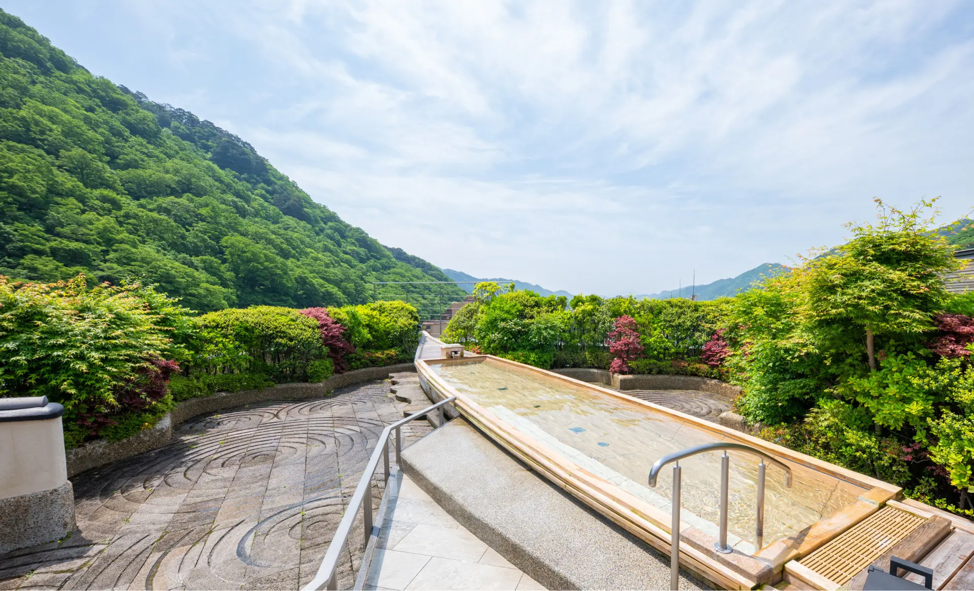 あさやホテル秀峰館 — 鬼怒川渓谷側の外観、新緑期の渓谷と高層棟