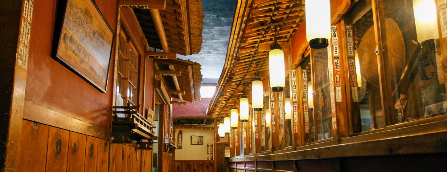 歴史の宿 金具屋 — 渋温泉 · 登録有形文化財「斉月楼」の木組みと吊り行灯の連なる廊下