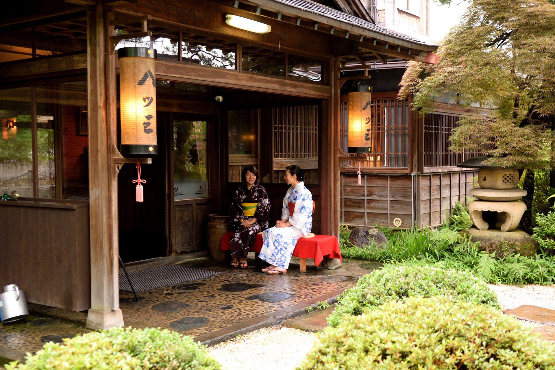 八ツ三館 — 飛騨古川・瀬戸川端 · 八ツ三の行灯が下がる玄関と苔むす前庭、百七十年続く料亭旅館