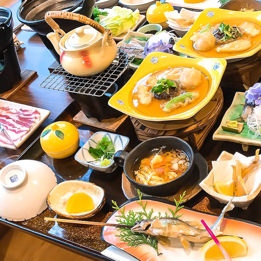 神湯荘 — 夕餉の会席 · 十津川のアマゴの塩焼き、鹿肉、温泉しゃぶしゃぶを並べた谷の膳