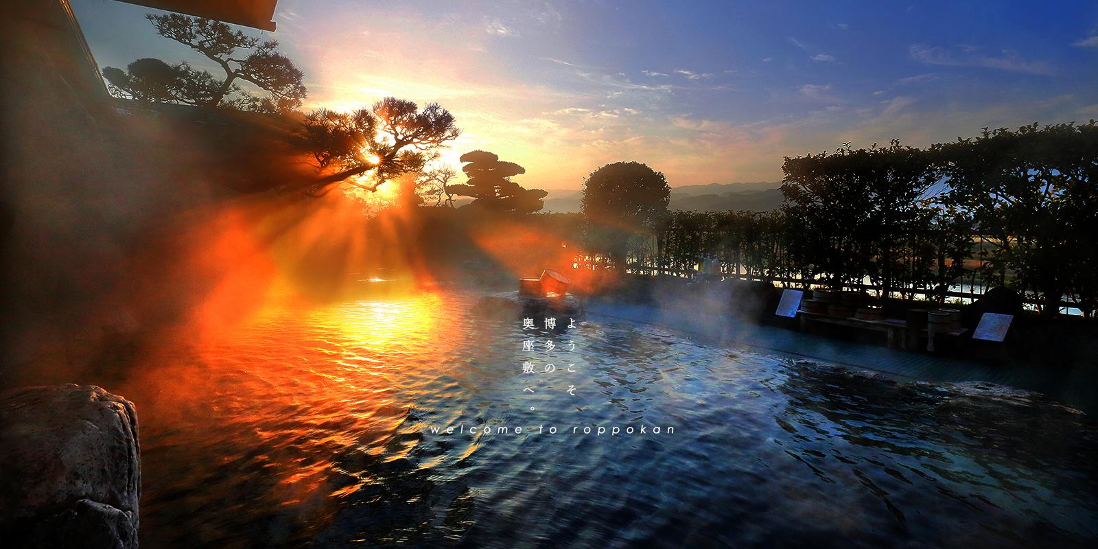 六峰舘 — 福岡県朝倉市原鶴温泉 · 筑後川を望む露天風呂に夕日が差し、湯気が立つ