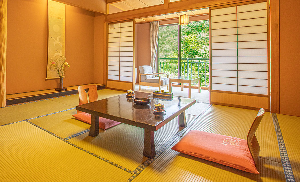 白鷺湯 たわらや — 加賀市山中温泉 · 床の間に掛軸と生花を配し、渓谷を望む数寄屋風の和室