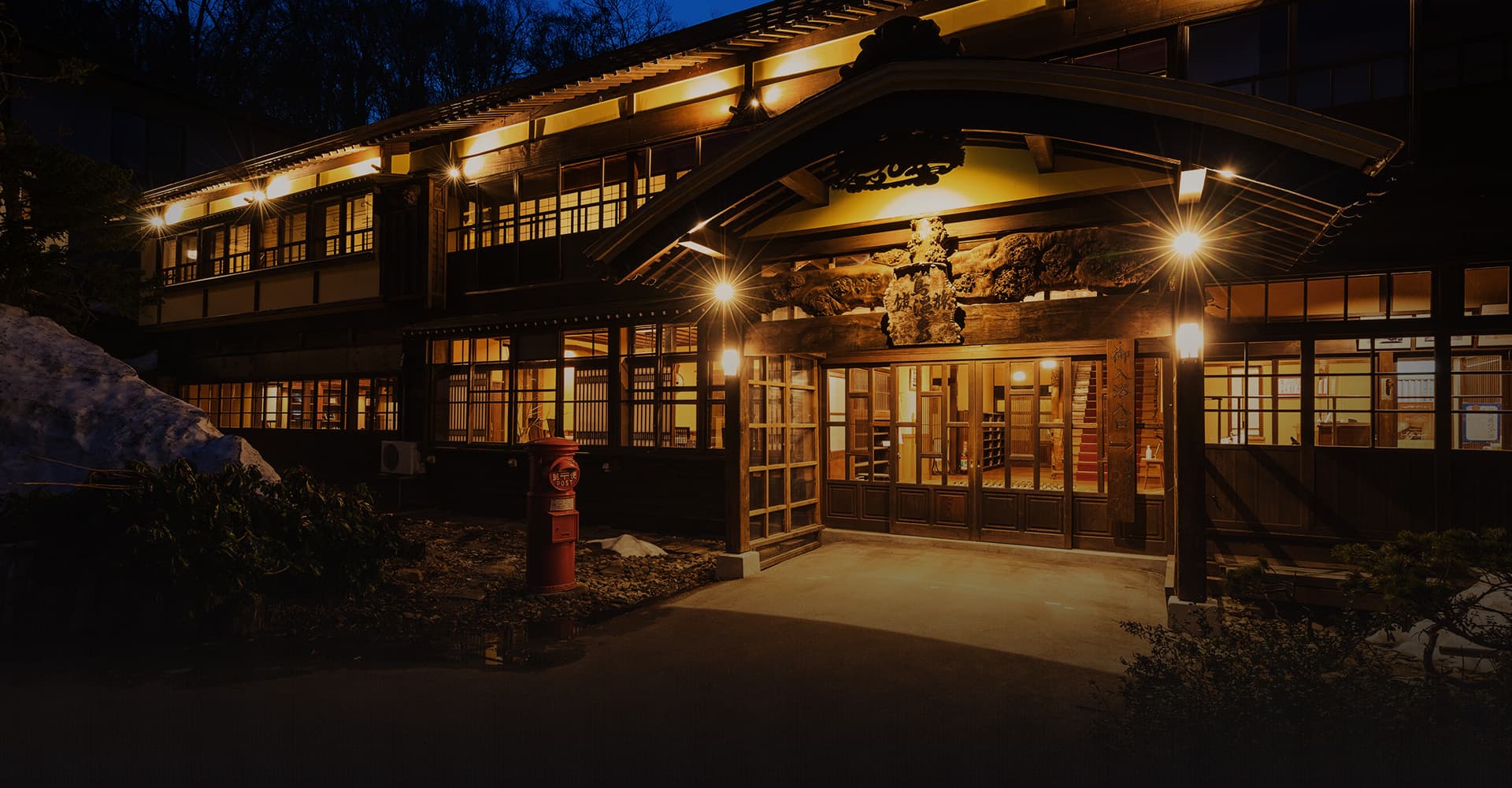蔦温泉旅館 — 青森・十和田市 · 大正期の木造本館、夕暮れに障子明かりの灯る玄関