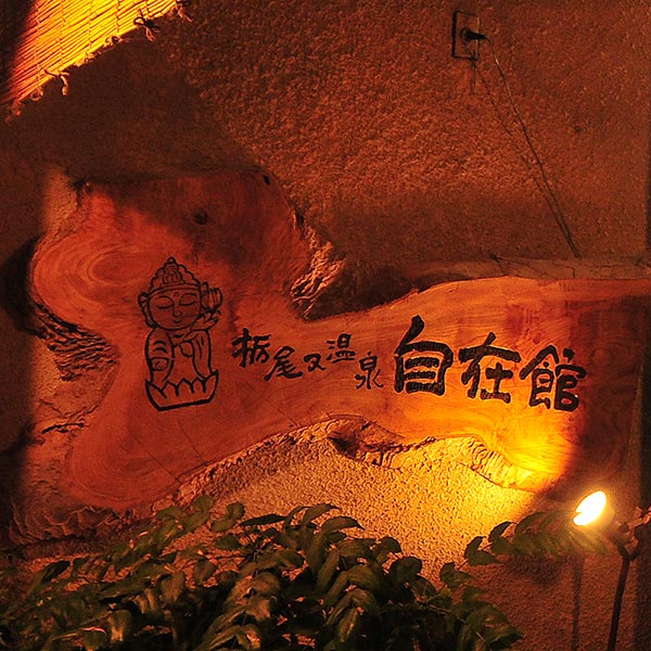 栃尾又温泉 自在館 — 屋号の由来となった観自在菩薩の意匠を刻む大樹の看板、夜の行灯