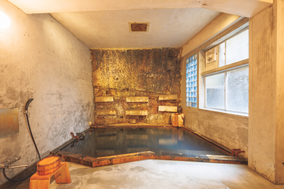 旅館ますや — 源泉かけ流しの内湯 · 湯の花が堆積した岩肌に囲まれた貸切の湯船