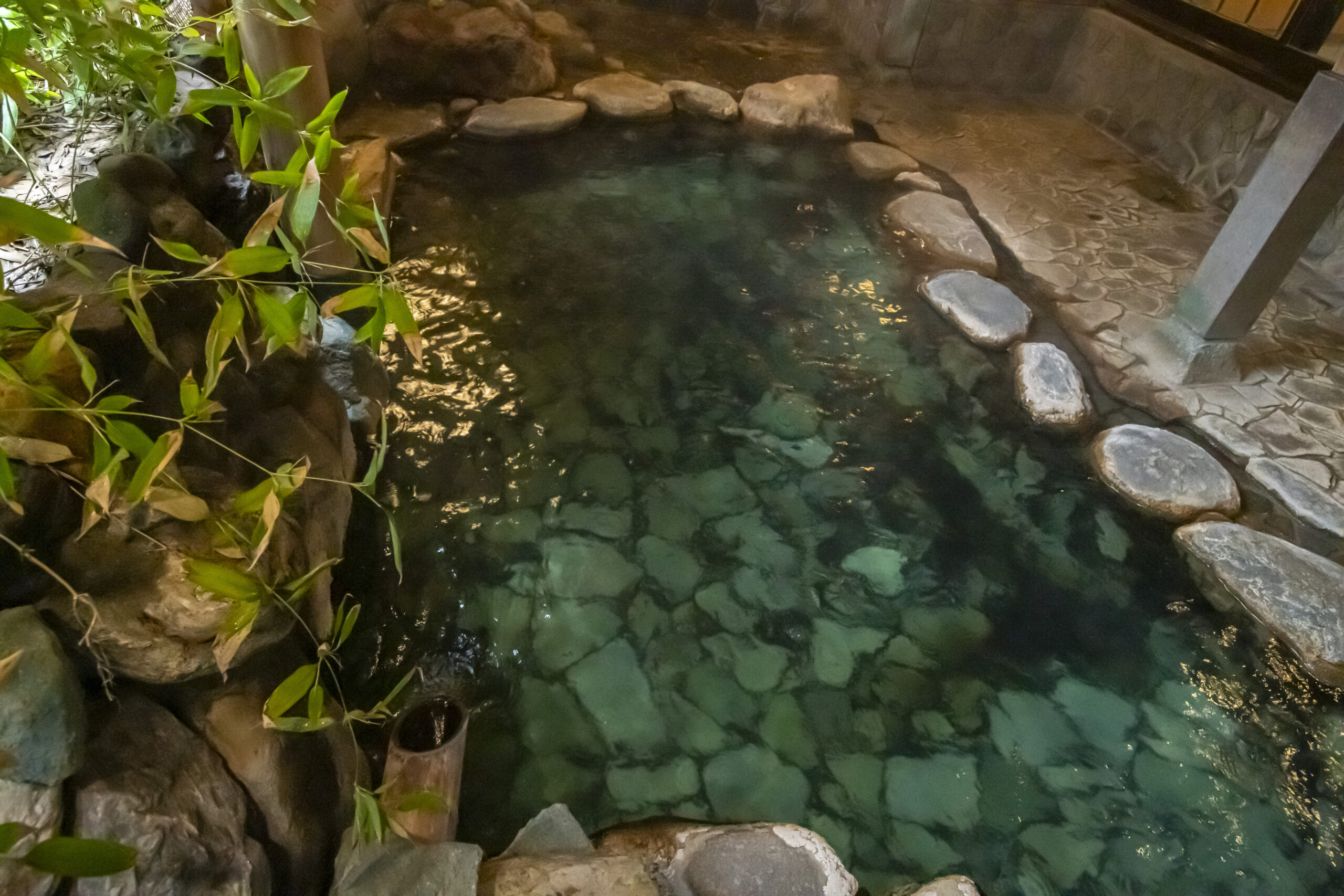 岩井屋 — 露天風呂「背戸の湯」、竹垣と岩に囲まれ木漏れ日の落ちる源泉かけ流しの湯