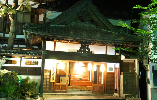 中嶋旅館 — 岩手県花巻市台温泉 · 木造四階建ての玄関まわり、夜の軒明かり