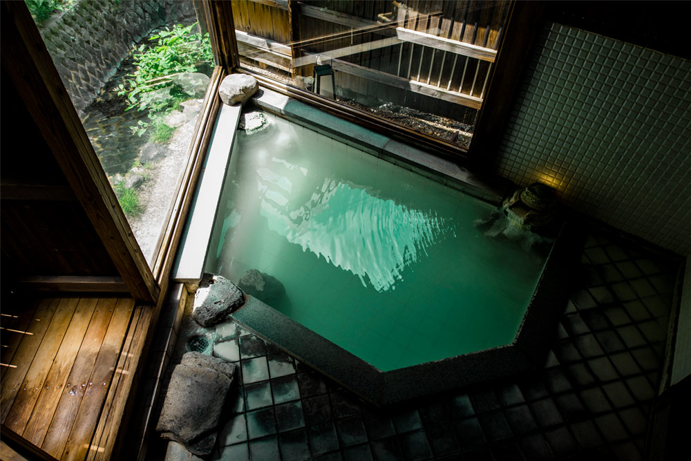 深山荘 高見屋 — 山形市・蔵王温泉 · 自家源泉の乳白色の湯をたたえる石造りの浴槽