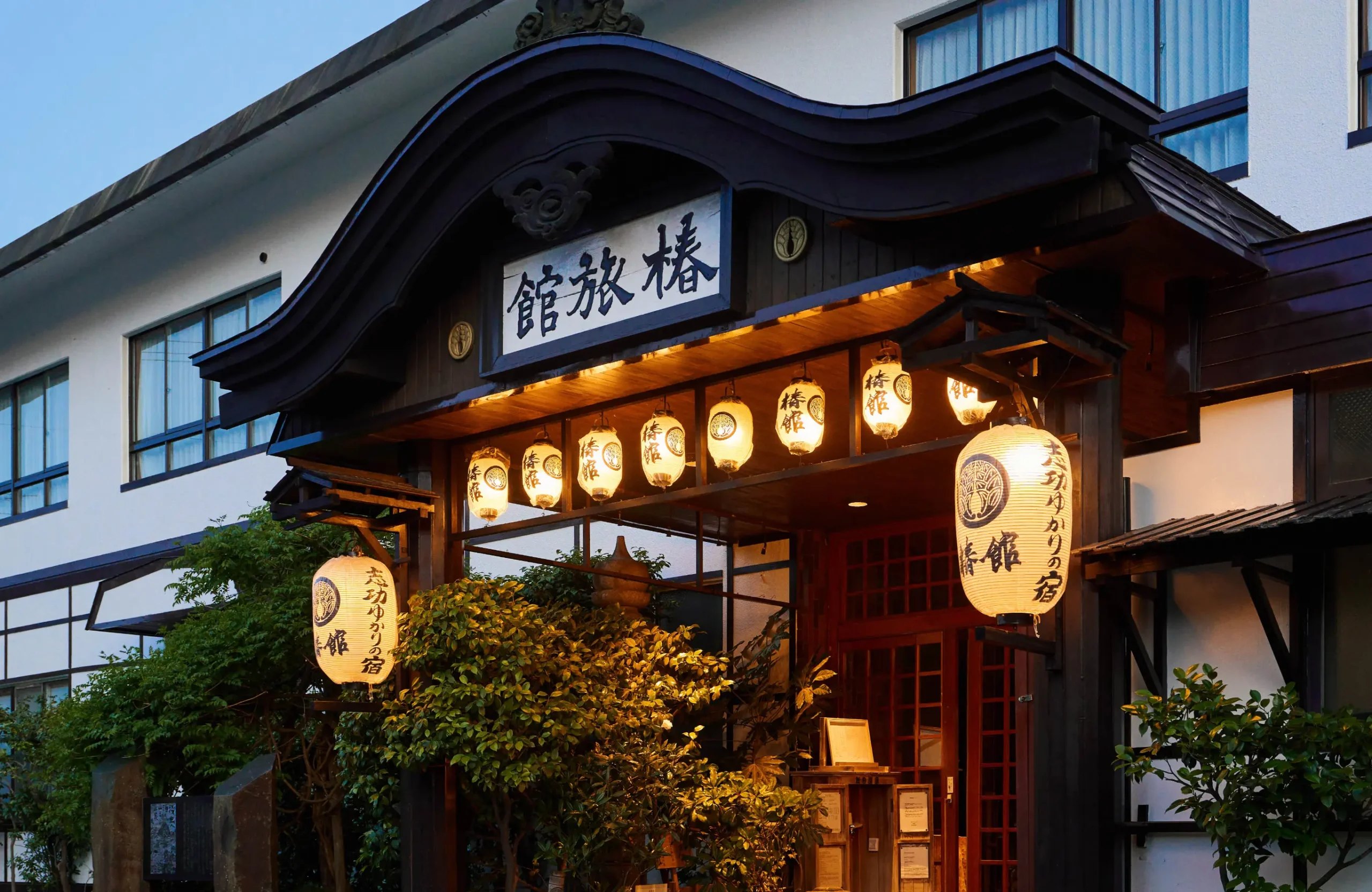 椿館 — 青森市・浅虫温泉 · 唐破風の玄関に「志功ゆかりの宿」の提灯が灯る夕景
