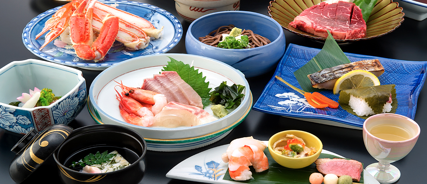 月本屋旅館 — 兵庫県豊岡市城崎温泉 · 松葉がにと但馬牛、日本海の刺身を並べた会席