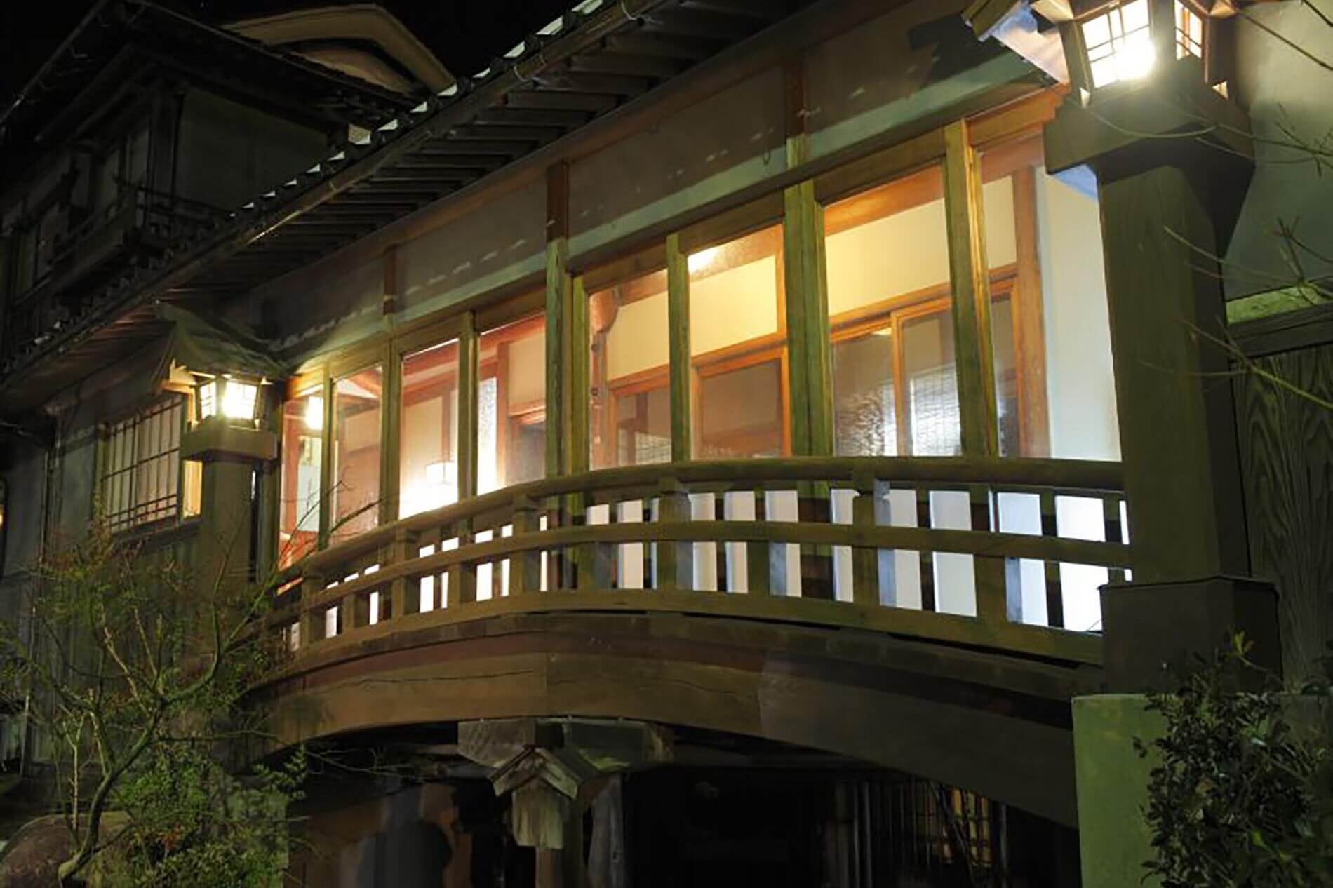 旅館大橋 — 三朝温泉 · 国登録有形文化財の太鼓橋と木造の外廊下、夜の灯り