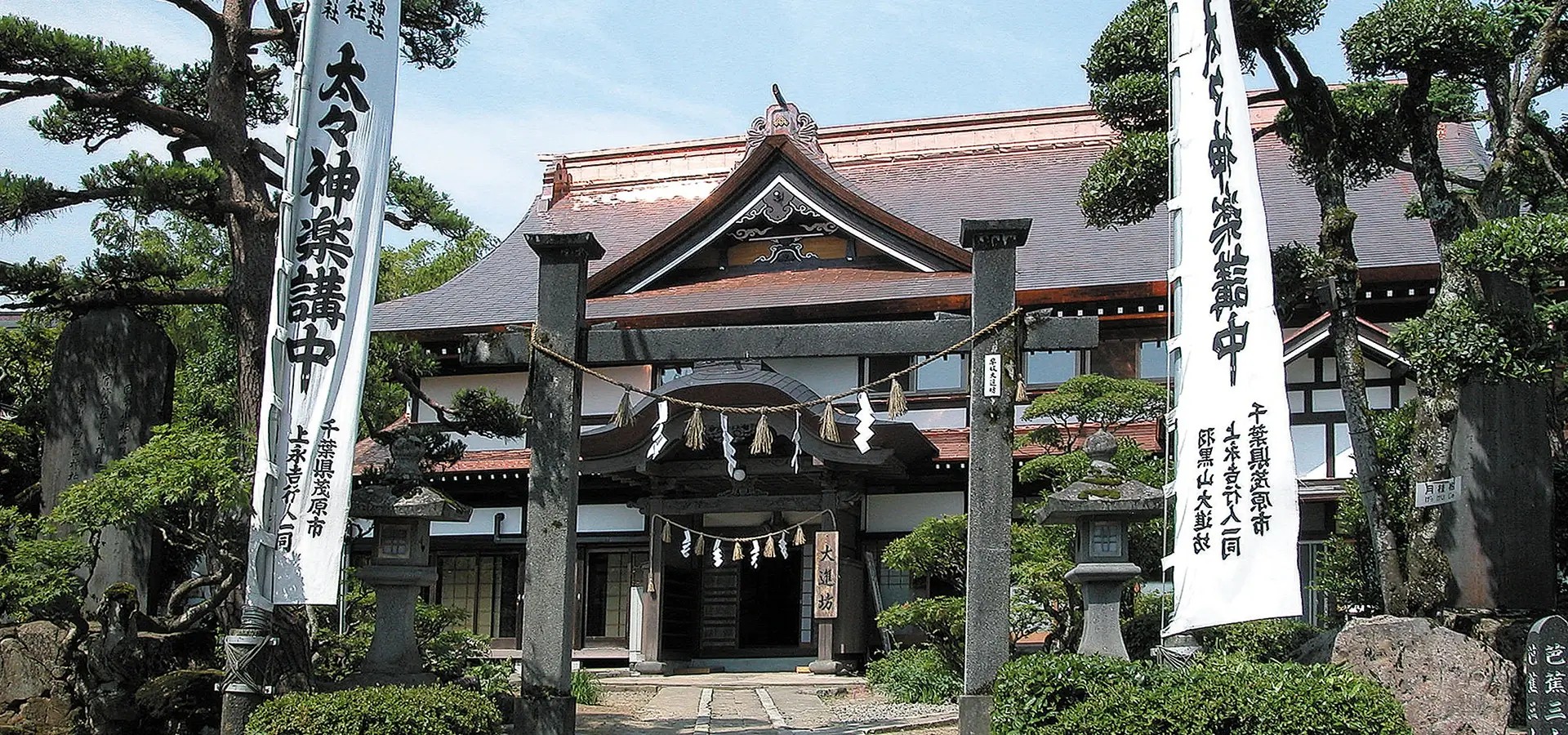 宿坊 大進坊 — 鶴岡市羽黒町手向 · 注連縄を張った鳥居越しに見る銅板葺入母屋造りの本館