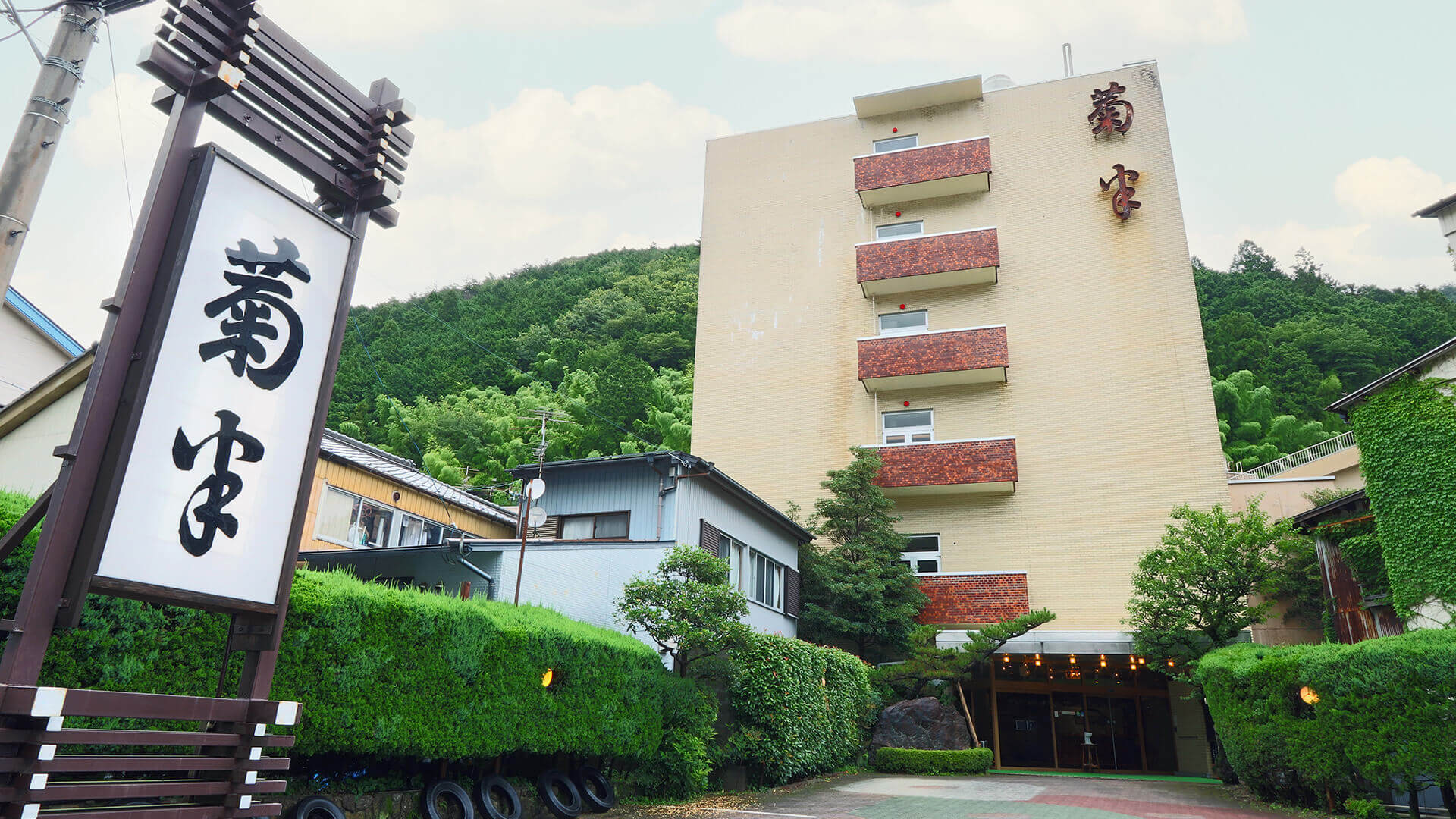 菊半旅館 — 下呂市湯之島 · 温泉街の中心に門を構える5階建ての素泊まり旅館の外観