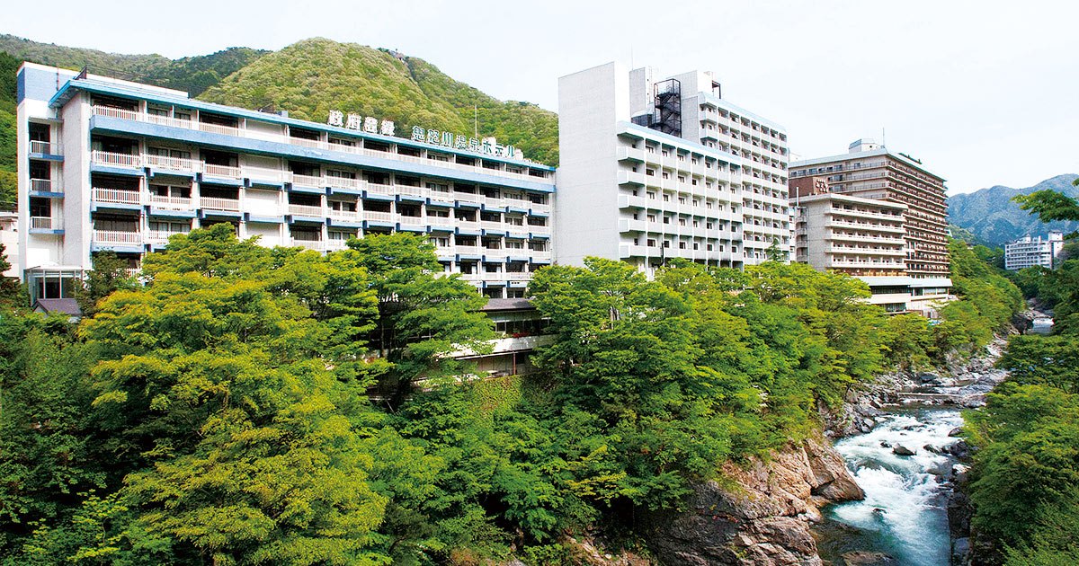 鬼怒川温泉ホテル — 日光市鬼怒川温泉滝 · 鬼怒川の渓谷沿いに建つ白い客室棟の外観