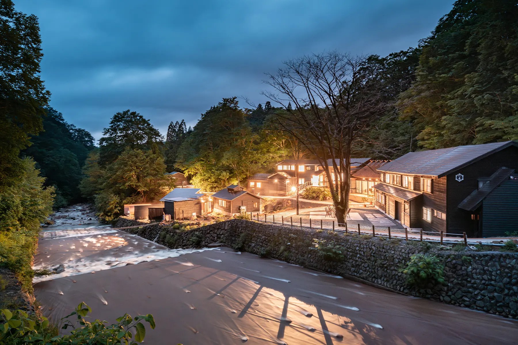 孫六温泉 六庵 — 秋田県仙北市・乳頭温泉郷 · 先達川のほとりに湯小屋と離れが並ぶ、明治35年開湯の湯宿の夕景