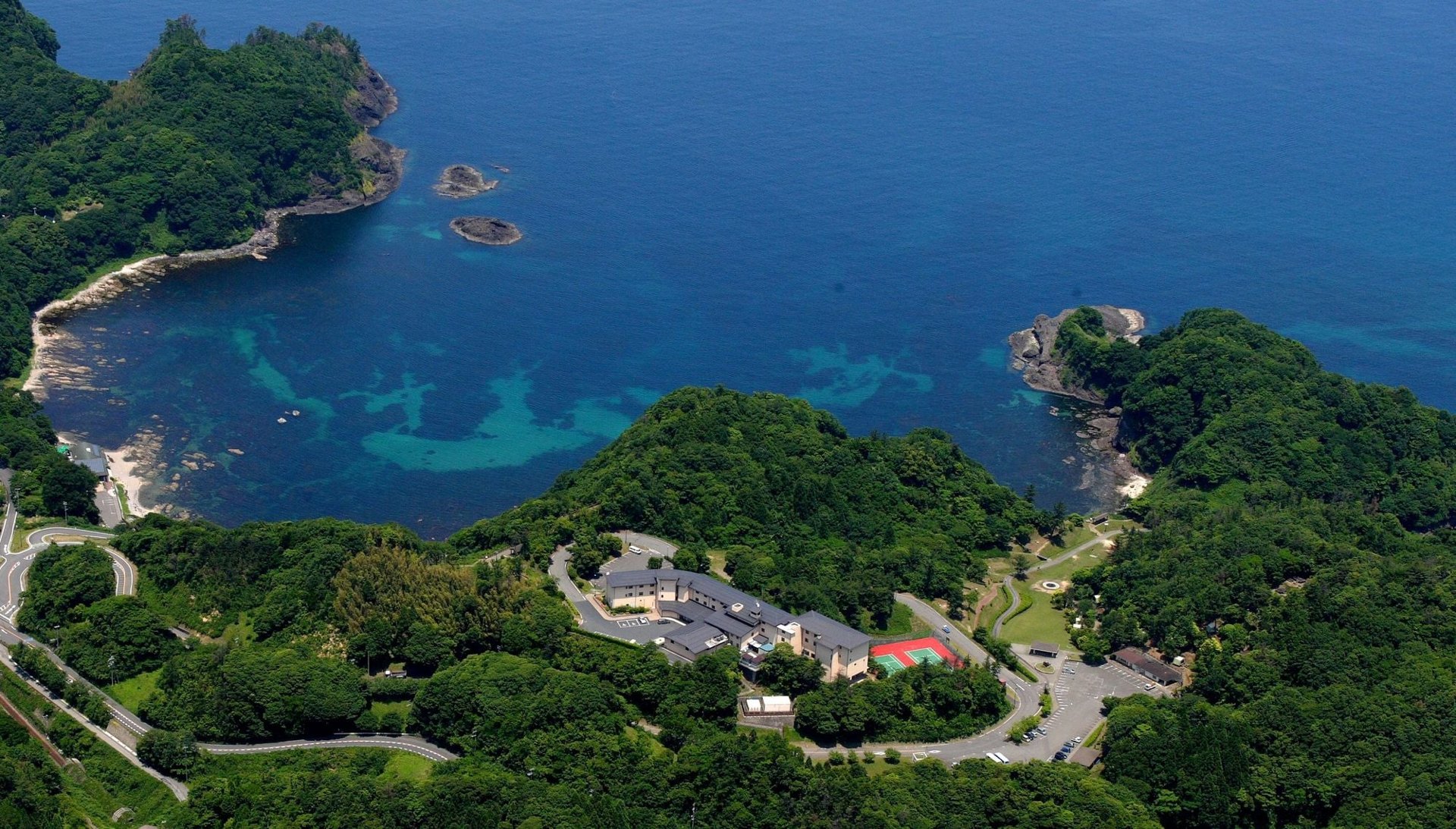 休暇村竹野海岸 — 豊岡市竹野町 · 山陰海岸国立公園の入江を見下ろす丘の上の宿を空から