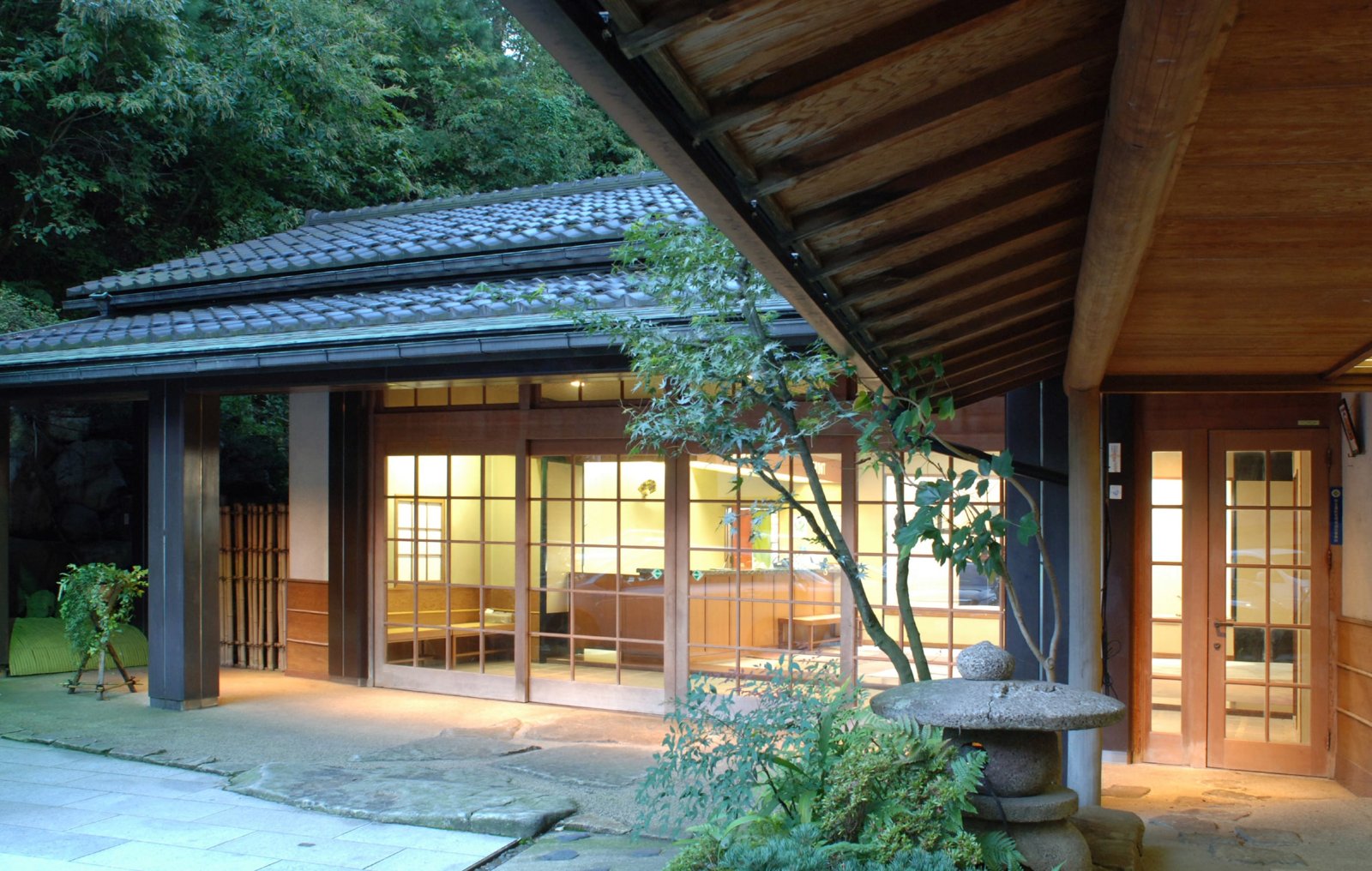 吉田屋山王閣 — 加賀市山代温泉 · 庭の緑に面した木造の客棟と軒先