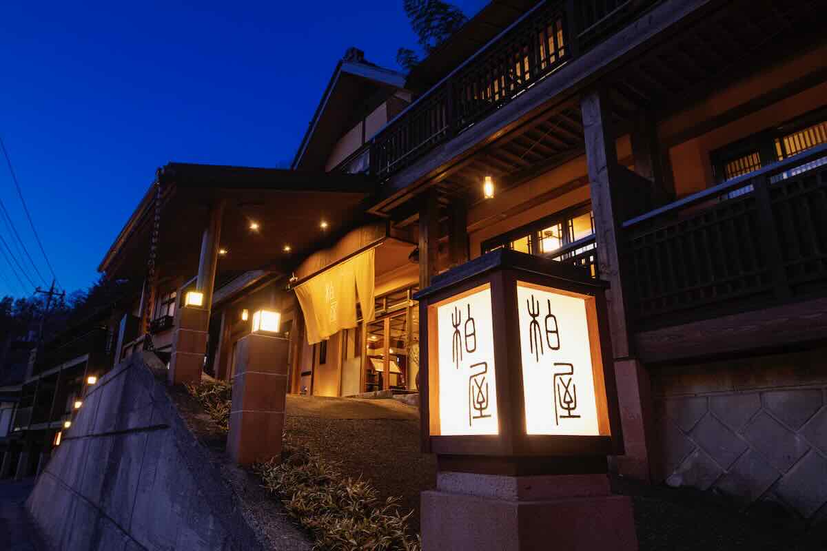 柏屋旅館 — 群馬・四万温泉 · 屋号の行灯が灯る夕暮れの玄関