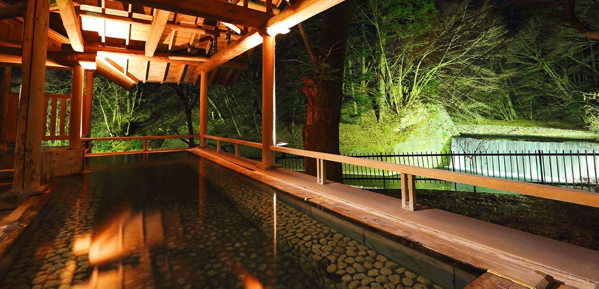 四万たむら — 群馬・四万温泉 · 森に面した夜の露天風呂「森のこだま」