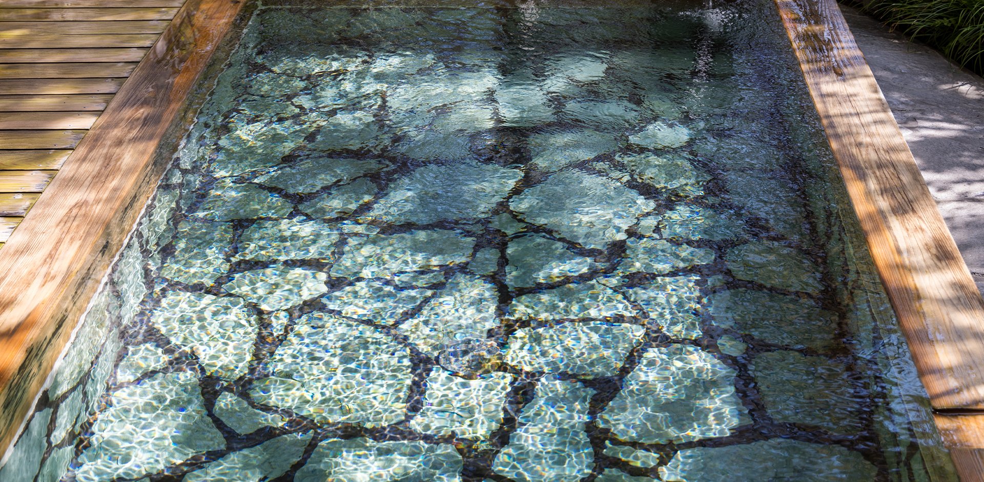 由布院 玉の湯 — 由布市湯布院町 · 木枠の湯船に石を敷いた露天風呂、無色透明の単純温泉