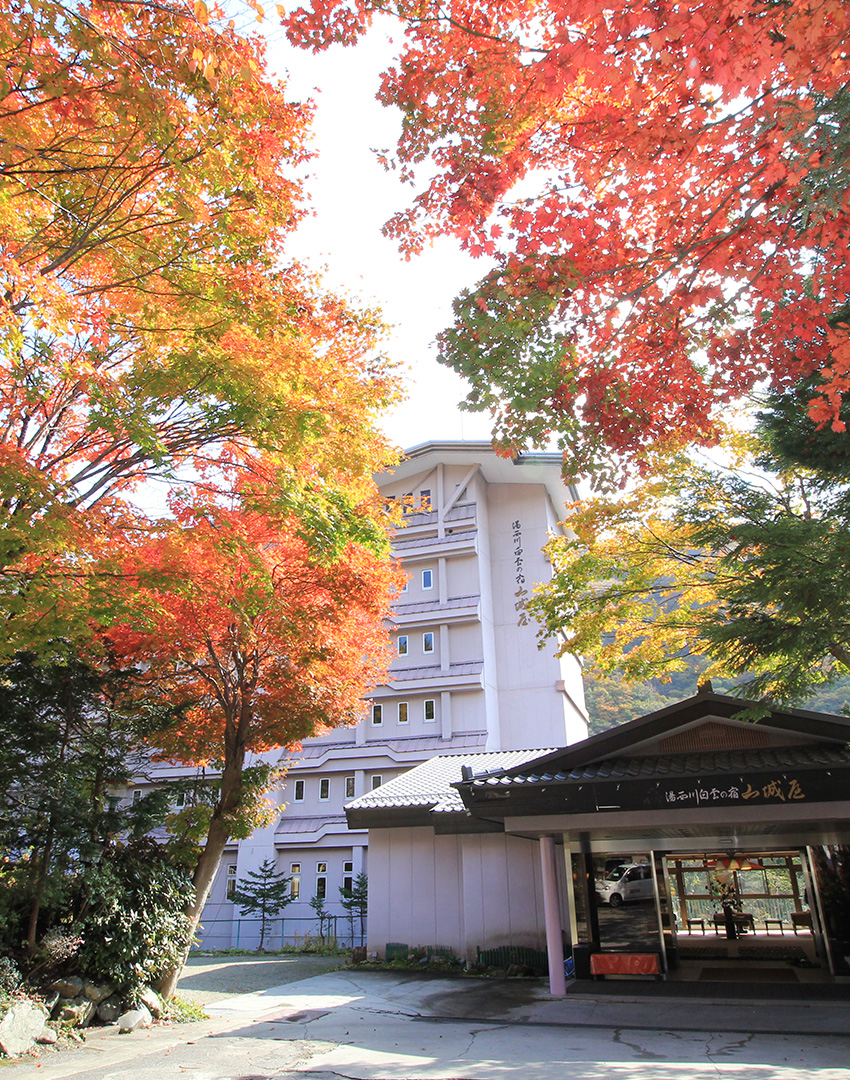 湯西川白雲の宿 山城屋 — 日光市湯西川 · 紅葉に囲まれた玄関と渓谷沿いの建物