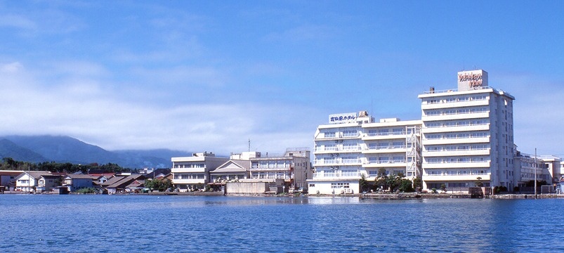 湖畔の宿 吉田家 — 佐渡市両津夷 · 加茂湖の対岸から望む東館・南館と湖畔の街並み